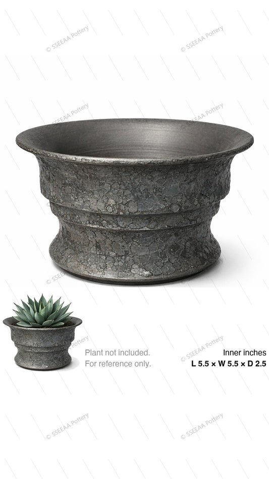 Dark gray textured footed pot with a wide flared rim and weathered stone-like surface.