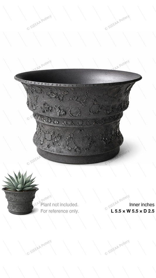 Charcoal textured footed pot with wide flared rim and craggy surface