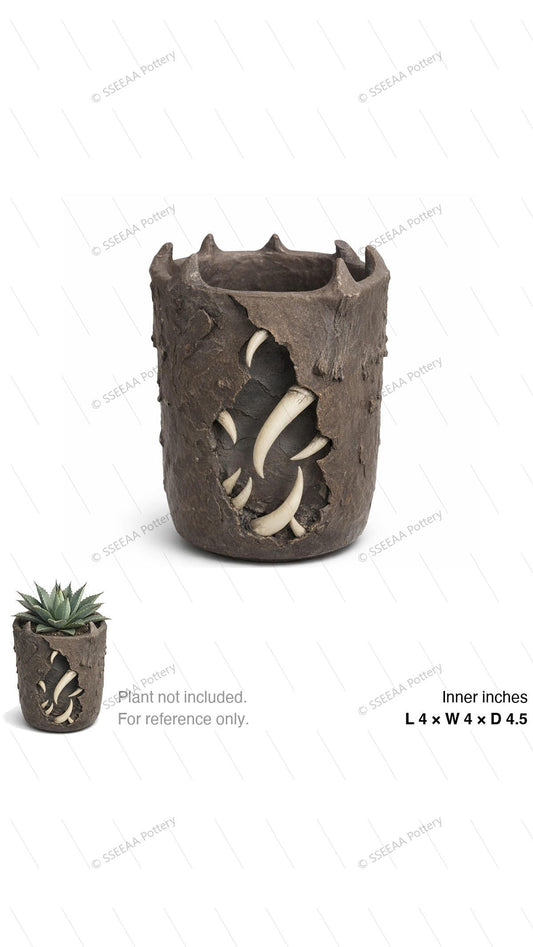 Dark sculptural tabletop pot with claw-like rim and weathered brown surface, shown empty on white background.