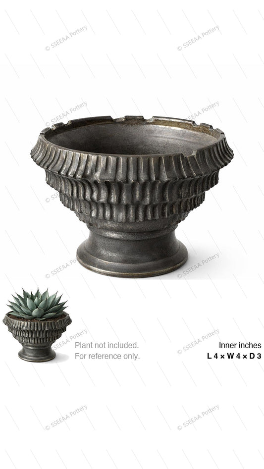 Dark gray footed pot with fluted ribbing and a wide flared rim.
