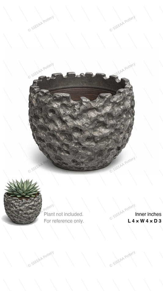 Textured dark gray tabletop pot with craggy stone-like surface and flared rim.